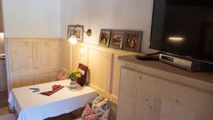 ein Wohnzimmer mit Tisch und Fernseher in der Unterkunft Beim Melchern in Fischbachau