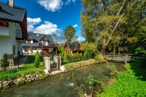 a house next to a river with houses at Domek u Eli in Czarny Dunajec