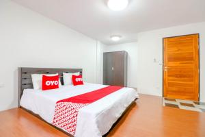 a bedroom with a large bed with red pillows at OYO 935 The Palm Apartment in Bangkok