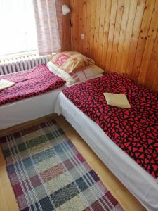 a bedroom with two twin beds and a rug at POĽSKÁ KRČMA in Vysoke Tatry - Horny Smokovec