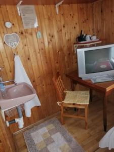 a bathroom with a sink and a desk with a tv at POĽSKÁ KRČMA in Vysoke Tatry - Horny Smokovec