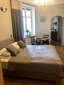 ein Schlafzimmer mit einem Bett und einem Tisch in einem Zimmer in der Unterkunft Apartament Starówka Łagiewniki in Danzig