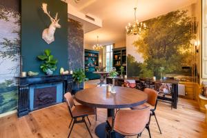 a dining room with a fireplace and a table and chairs at Stayokay Hostel Domburg in Oostkapelle