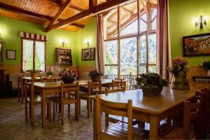 a dining room with green walls and wooden tables and chairs at CASA RURAL TOKI ONA in Valcarlos