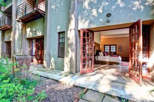 una puerta abierta de un edificio con una cama en Bramasole Boutique Hotel, en Magoebaskloof