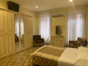 a bedroom with a bed and a chair and a mirror at Hotel Croce Di Malta in Rome