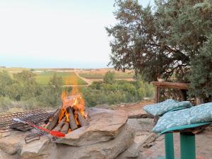 a fire pit with a fire grill and a bench at Melkboomsdrift Guest House & Conference Centre in Vredendal