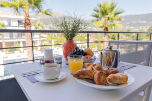 a table with a breakfast of coffee and croissants and orange juice at Evancy Les Jardins d'Azur - Vence in Vence