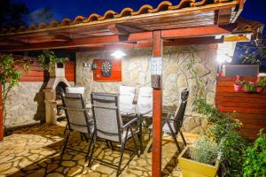 a table and chairs on a patio with a stone wall at Holiday Home Casa Bianca in Malinska