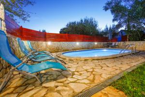 a swimming pool with two chairs and a fence at Holiday Home Casa Bianca in Malinska
