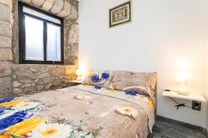 a bedroom with a bed and a stone wall at Holiday Home Casa Bianca in Malinska +50 photos