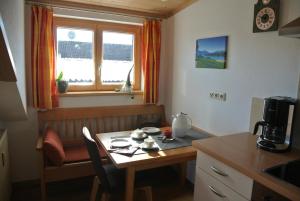 une petite cuisine avec une table et une table ainsi qu'une fenêtre dans l'établissement Ferienhaus Breyer, à Hopferau