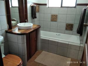a bathroom with a sink and a bath tub with a sink at Hanlin Lodge in Modimolle +13 photos