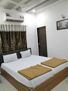 a bedroom with a large bed in a room at Hotel neptune in Amreli
