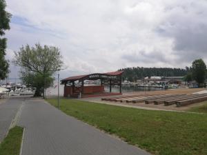 una parada de autobús con bancos frente a un puerto deportivo en Jacht motorowy Nautika 1300 VIP, en Wilkasy