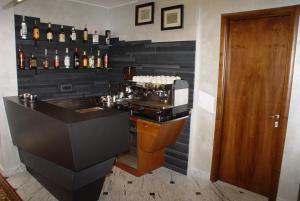 a bar with a black wall with bottles of alcohol at Hotel Iris in Genoa