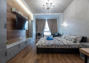 a bedroom with a bed and a tv and a couch at Дизайнерські апартаменти на Оболоні в ЖК Smart Plaza Obolon біля станції метро Мінська in Kyiv