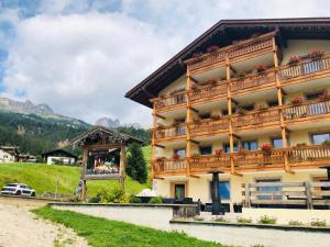 a large building with a horse on top of it at Wellness Hotel Dolomia in Soraga