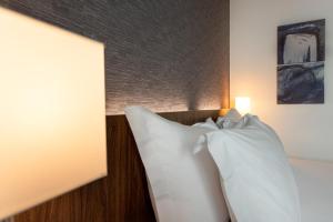 a bed with a white blanket and pillows on it at Holiday Inn Express Lisbon Airport, an IHG Hotel in Lisbon
