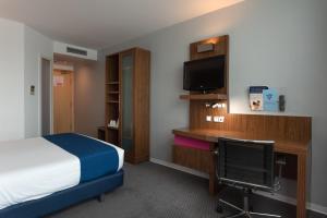 a bedroom with a bed and a desk at Holiday Inn Express Lisbon Airport, an IHG Hotel in Lisbon