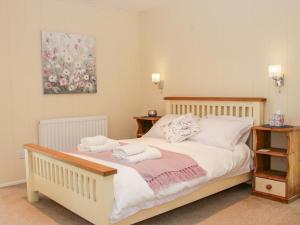 1 dormitorio con 1 cama con toallas en Alder River Lodge Clun Valley Luxury Hot Tub Break en Craven Arms
