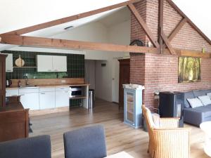 eine Küche und ein Wohnzimmer mit einer Ziegelwand in der Unterkunft Diekinkshof in Laren