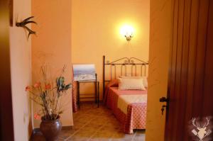 a bedroom with a bed and a lamp on the wall at Cueva La Panadera - CuevasCazorla in Hinojares +18 photos