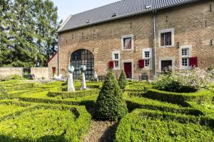 a garden in front of a brick building with bushes at Meschermolen 3 in Withuis