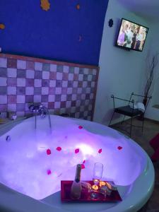 a bath tub with a bottle and a glass at Cueva Arroyo Molino - CuevasCazorla in Hinojares