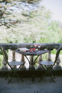 a table with two glasses of wine and two chairs at Chateau de Varenne in Sauveterre