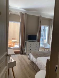 - une chambre avec un lit et une télévision sur une commode dans l'établissement Villa d'Estelle, à Cannes