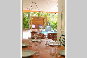 a dining room with a table with wine glasses at VILLA KADAL, perle rare à 50m du lagon… in La Saline les Bains
