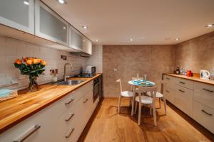Una cocina con gabinetes blancos y una mesa con sillas. en ALPARI apartments, en Cracovia 8 fotos más