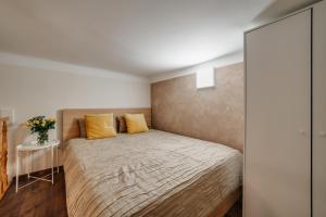 a bedroom with a large bed with yellow pillows at ALPARI apartments in Krakow
