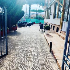 a tile walkway with chairs and tables on a building at Hotel San Giorgio in Albisola Superiore