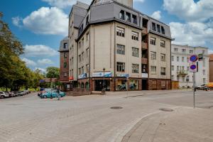 a building on a street with a blue car in front at University City Heart, Tartu Home in Tartu