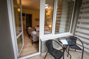 balkon z 2 krzesłami i stołem oraz pokój w obiekcie Hotel Orle w Gdańsku