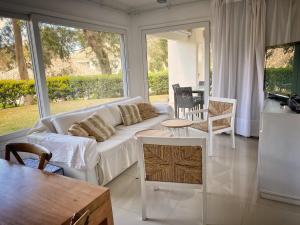 uma sala de estar com um sofá e uma mesa em Green Park Solanas Departamento en PB con Jardín y Parrillero em Punta del Este