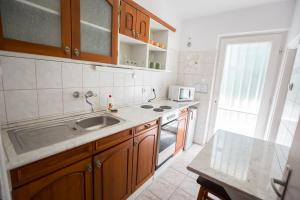 a kitchen with a sink and a stove top oven at Panzió LEMBERG in Hajdúszoboszló