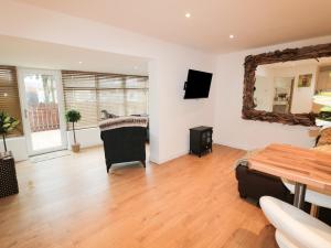 a living room with a table and a mirror at Swale Cottage in Chathill