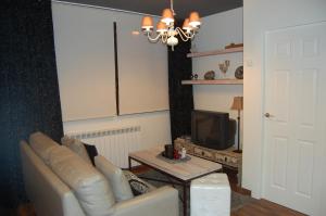 sala de estar con sofá y TV en Apartamento Garona, en Vielha