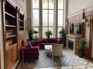 a living room with red couches and a fireplace at Boutique Hotel Kaspi in Temirtaū