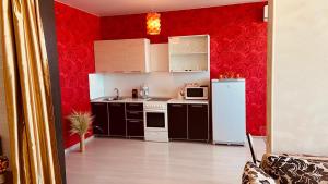 ペンザにあるApartment Plekhanova VIPの白い家電製品と赤い壁のキッチン
