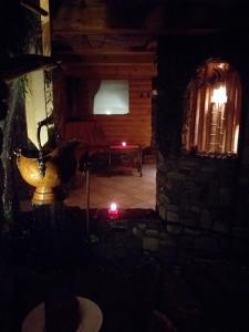 a dark room with a bench in a room with a candle at Zajazd pod Chmurką in Rabka-Zdrój