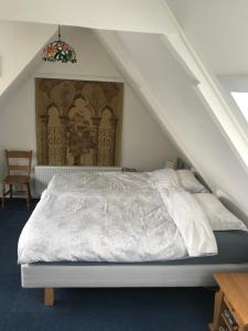 a white bed in a room with a staircase at B&B De Duinhoek in Beverwijk