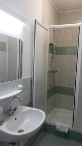 un baño con lavabo y ducha en Gitta Apartman, en Bük