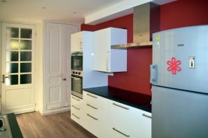 ダンケルクにあるGite l'Escale Maloの赤い壁のキッチン(白い冷蔵庫付)