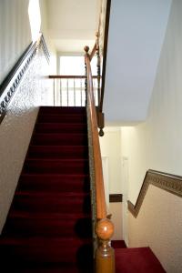 ダンケルクにあるGite l'Escale Maloの赤いカーペット敷きの階段と赤い階段