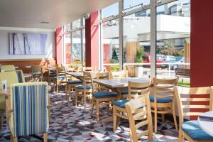 un restaurant avec des tables, des chaises et des fenêtres dans l'établissement Holiday Inn Southampton, an IHG Hotel, à Southampton