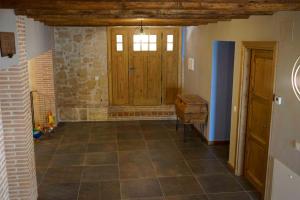 Habitación con puerta de madera y suelo de baldosa. en Casa Rural Bonal en La Mata de los Olmos